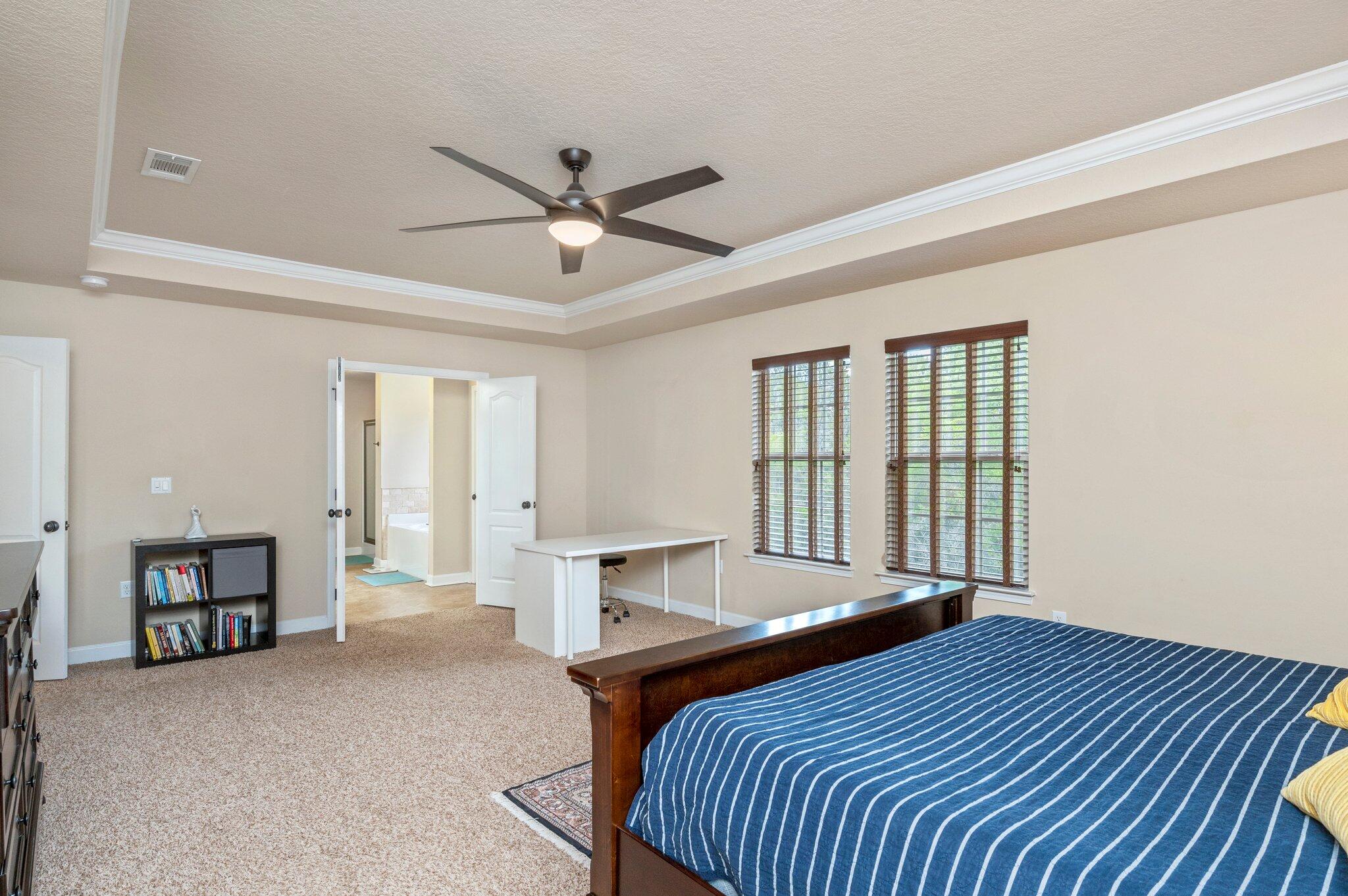 4558 Hermosa Road Crestview, FL 32539 - Photo 26 of 48 a bedroom with a large bed and a chandelier fan
