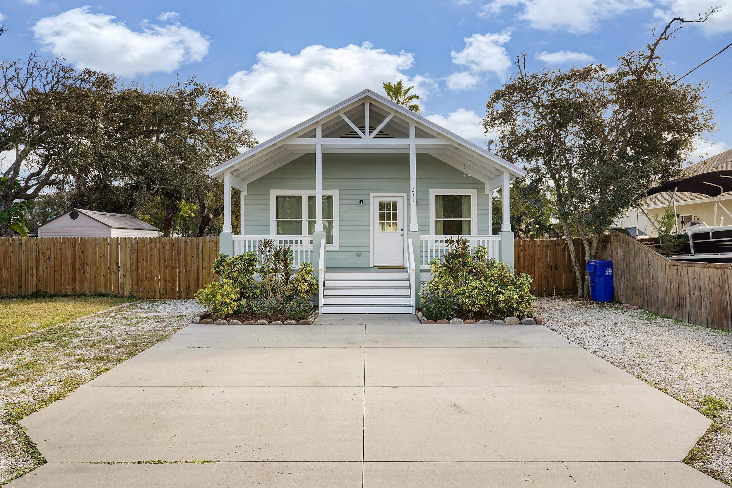 a view of a house with a small yard and wooden fence