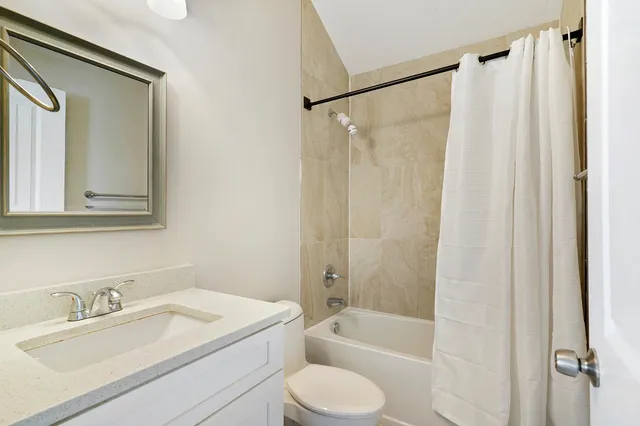 a bathroom with a granite countertop sink toilet and shower