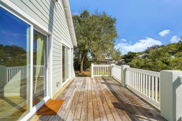 a view of balcony with wooden floor and fence