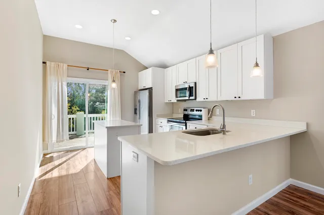 a kitchen with sink a microwave and cabinets