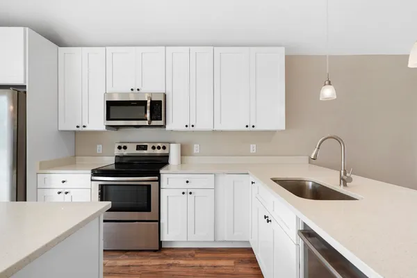 a kitchen with appliances a sink and cabinets