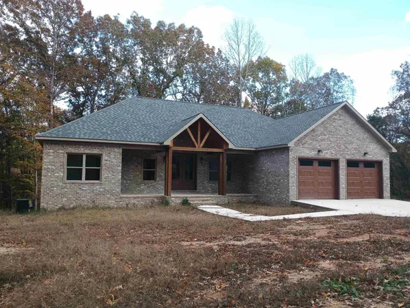 a front view of a house with yard and trees