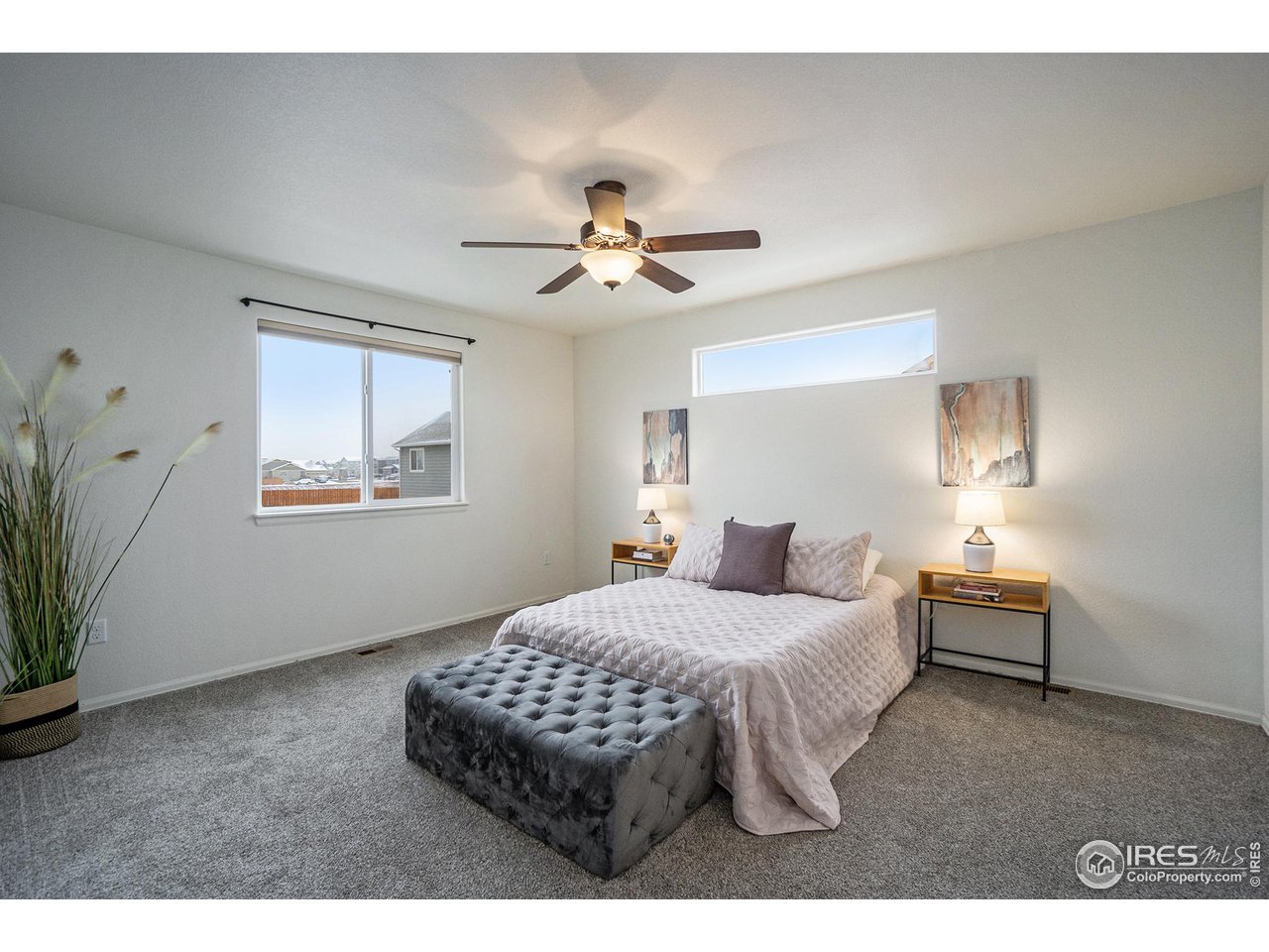 4386 Cypress Ridge Lane Wellington, CO 80549 - Photo 16 of 30 a bedroom with a bed and a chandelier