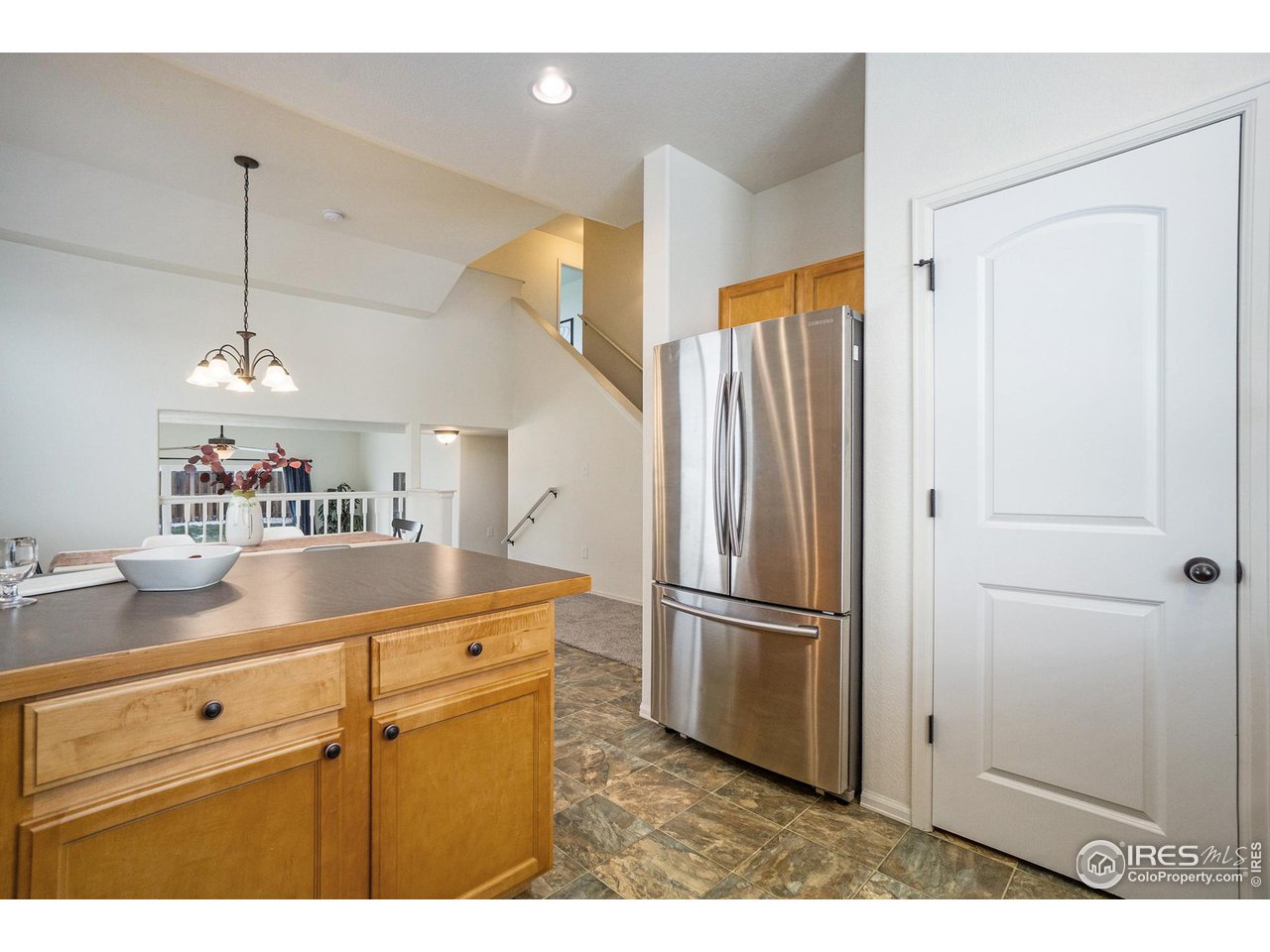 4386 Cypress Ridge Lane Wellington, CO 80549 - Photo 6 of 30 a kitchen with a refrigerator a sink and cabinets