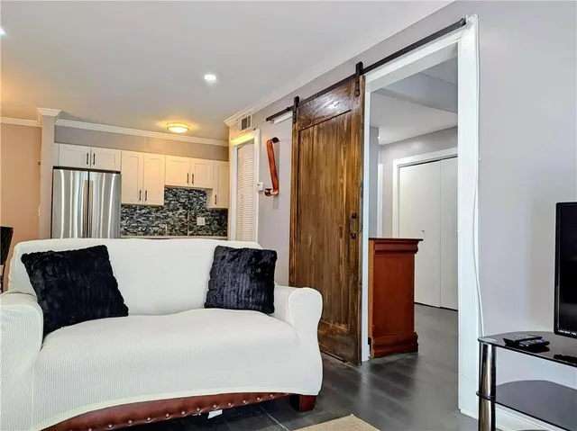 a living room with furniture and a glass door shower