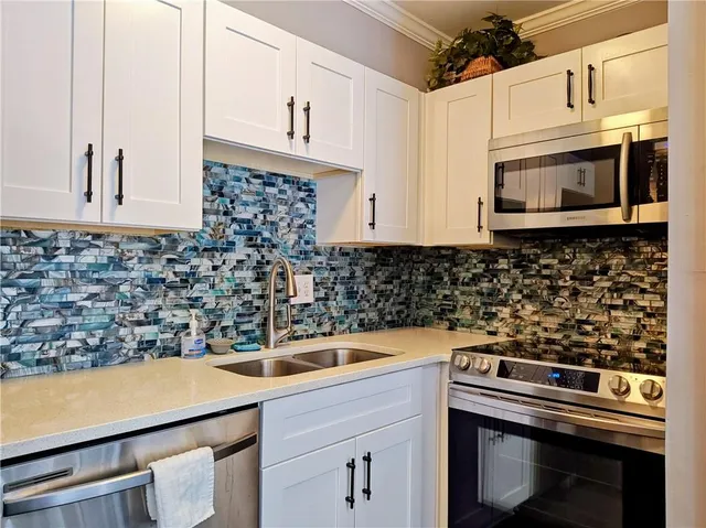 a kitchen with stainless steel appliances a refrigerator sink and microwave