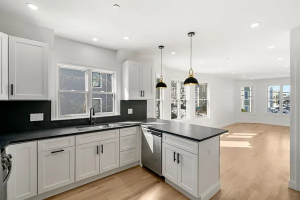 a large kitchen with stainless steel appliances kitchen island a large counter top and a wooden floors
