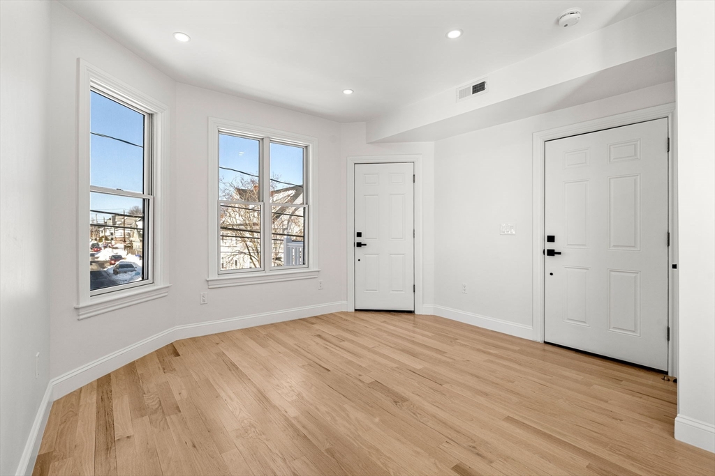 53 Dustin Street, Unit 2 Boston, MA 02135 - Photo 18 of 21 a view of an empty room with wooden floor and a window