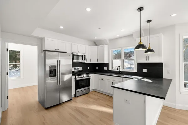 a kitchen with stainless steel appliances granite countertop a sink a stove and a refrigerator