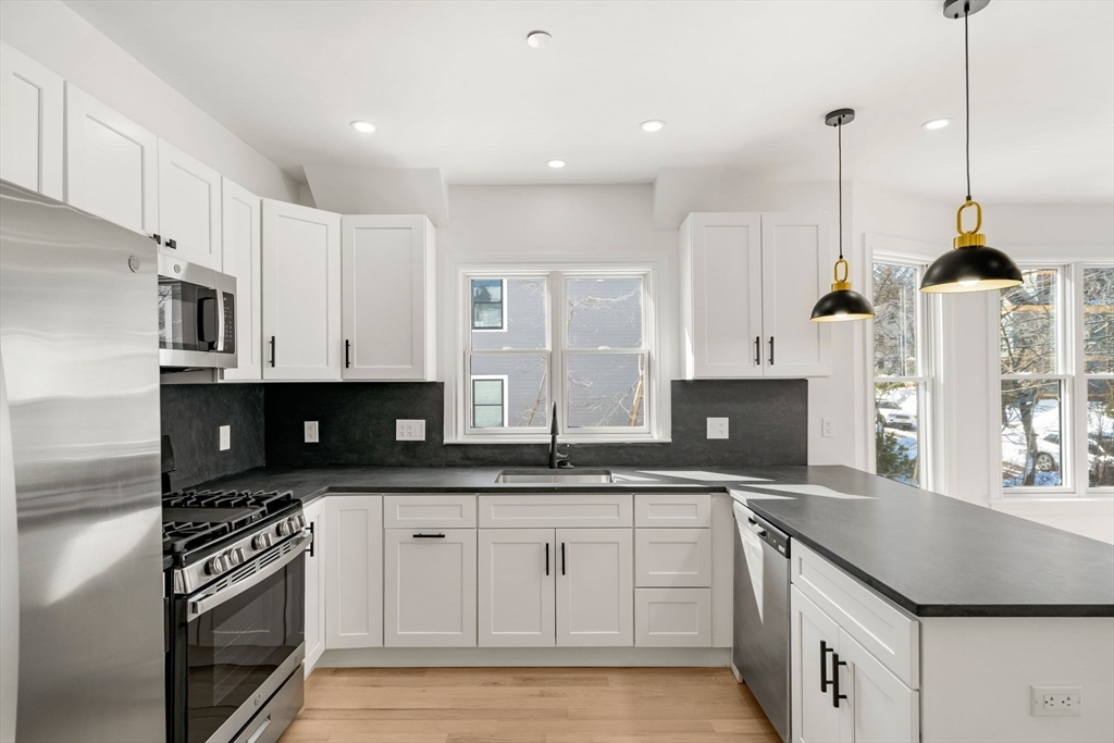 53 Dustin Street, Unit 2 Boston, MA 02135 - Photo 4 of 21 a kitchen with stainless steel appliances granite countertop a sink a stove and a refrigerator