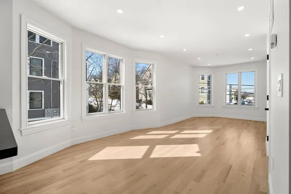 a large kitchen with stainless steel appliances kitchen island a large counter top and a wooden floor