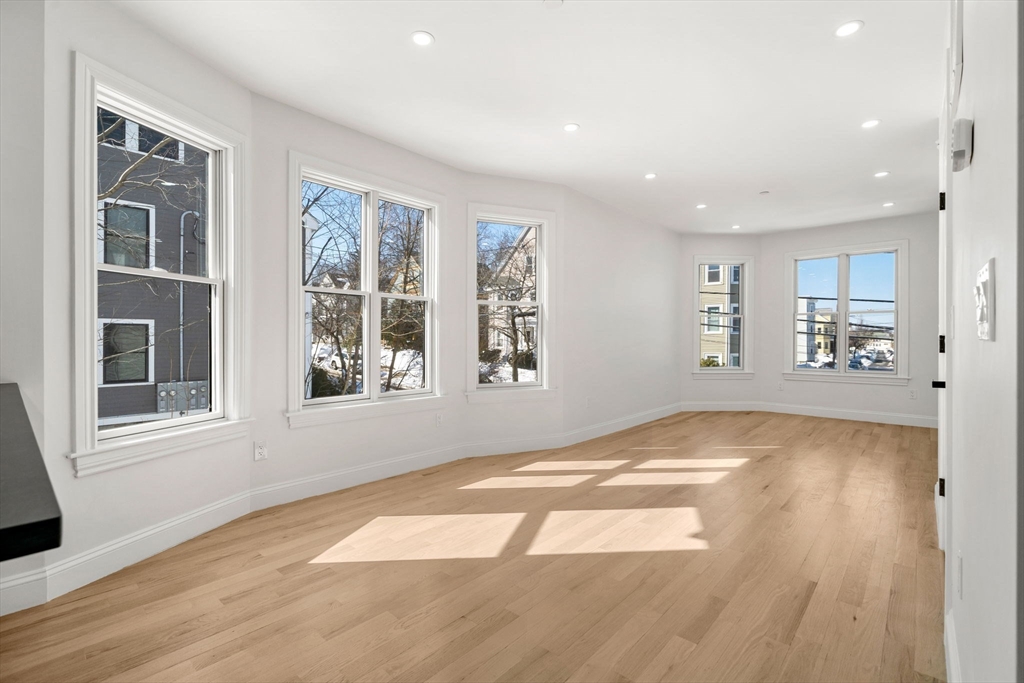 53 Dustin Street, Unit 2 Boston, MA 02135 - Photo 5 of 21 a view of an empty room with wooden floor and a window