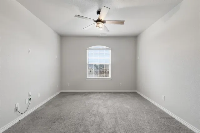 a view of a livingroom with a ceiling fan and window