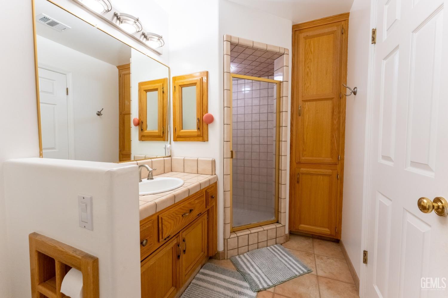 Undisclosed Address Bakersfield, CA 93314 - Photo 21 of 23 a bathroom with a sink a mirror and a shower