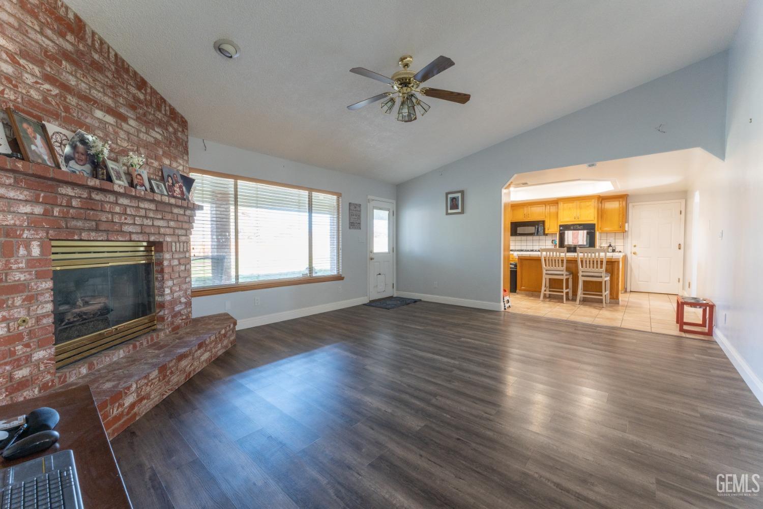 Undisclosed Address Bakersfield, CA 93314 - Photo 6 of 23 a view of an empty room with wooden floor fireplace and a window