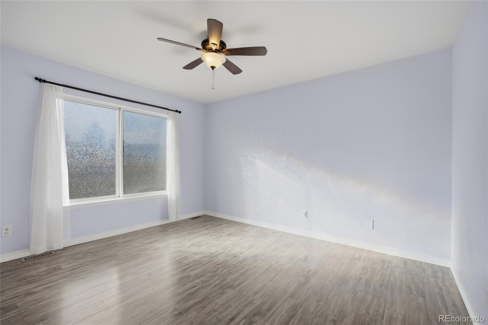 4531 Gibraltar Street Denver, CO 80249 - Photo 11 of 24 wooden floor in an empty room with a window