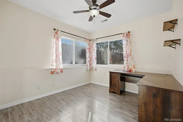 a view of a workspace with furniture and a window