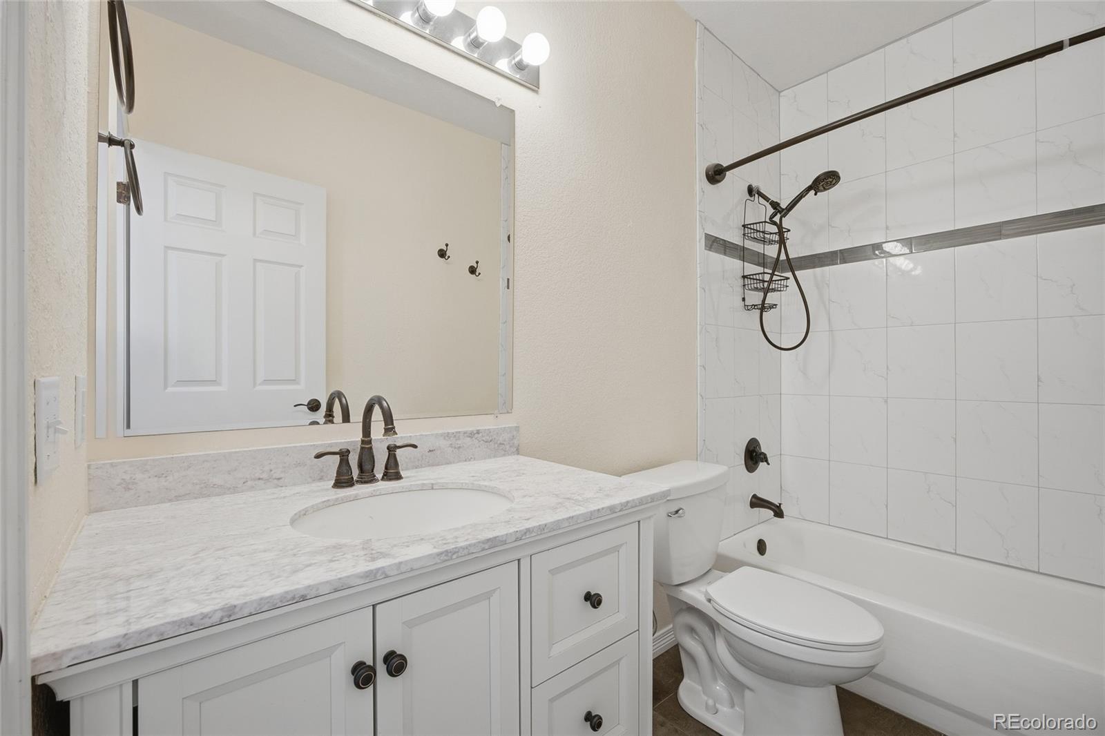 4531 Gibraltar Street Denver, CO 80249 - Photo 17 of 24 a bathroom with a sink a toilet and shower