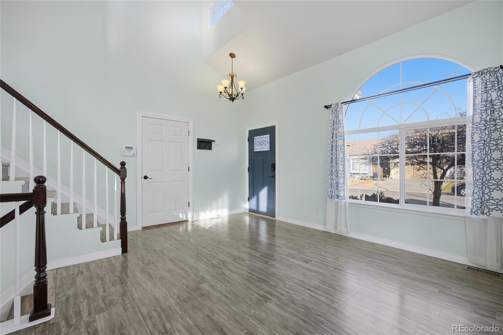 4531 Gibraltar Street Denver, CO 80249 - Photo 6 of 24 a view of an empty room with wooden floor and a window