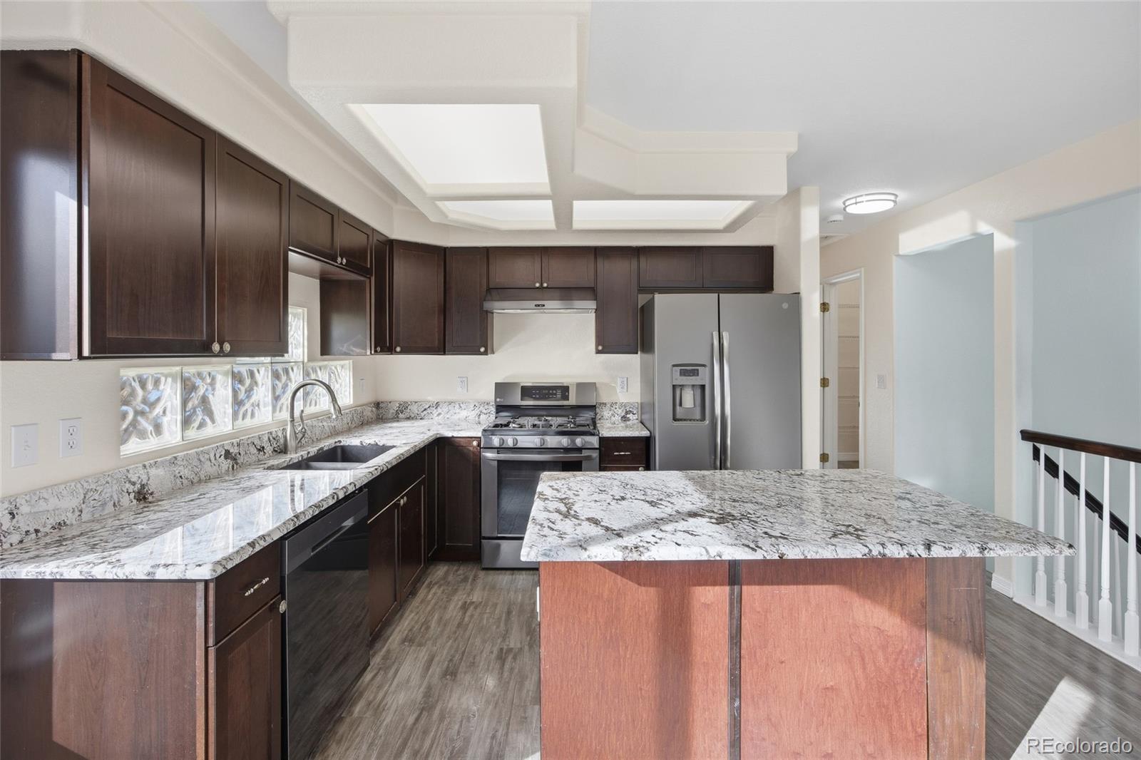 4531 Gibraltar Street Denver, CO 80249 - Photo 8 of 24 a kitchen with stainless steel appliances granite countertop a sink stove and refrigerator