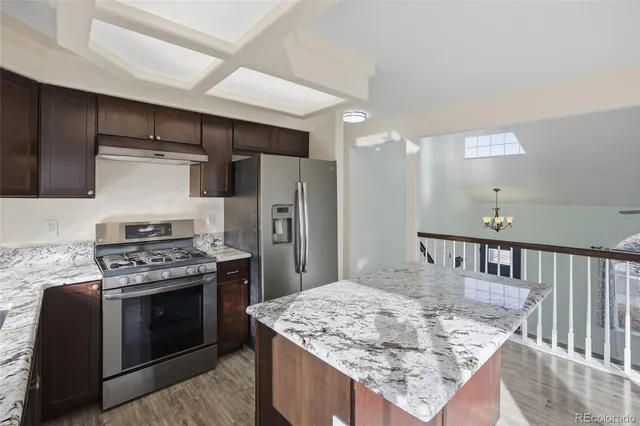 a kitchen with stainless steel appliances granite countertop a stove a refrigerator and a stove