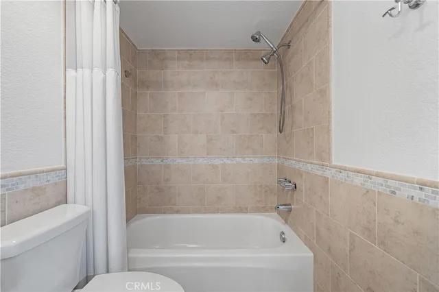 an empty room with chandelier fan and windows