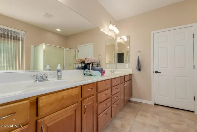 a spacious bathroom with double vanity a mirror and a bathtub