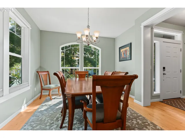 a dining room with furniture a chandelier and wooden floor