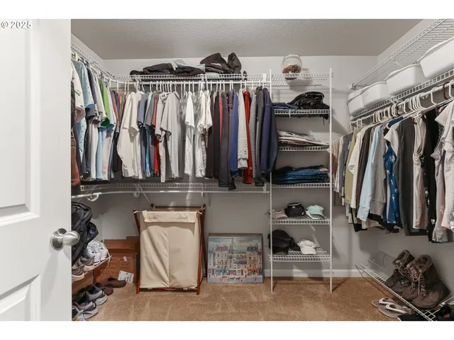 a view of walk in closet with clothes and shoes