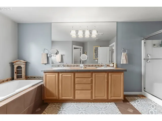 a spacious bathroom with a granite countertop sink a mirror and a bathtub