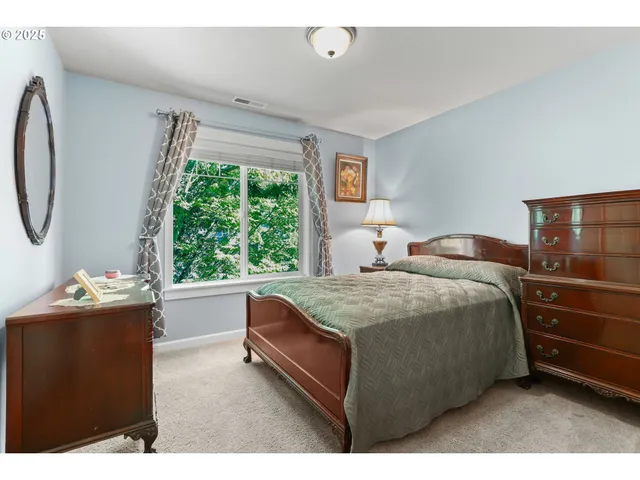 a bedroom with a bed dresser and a window