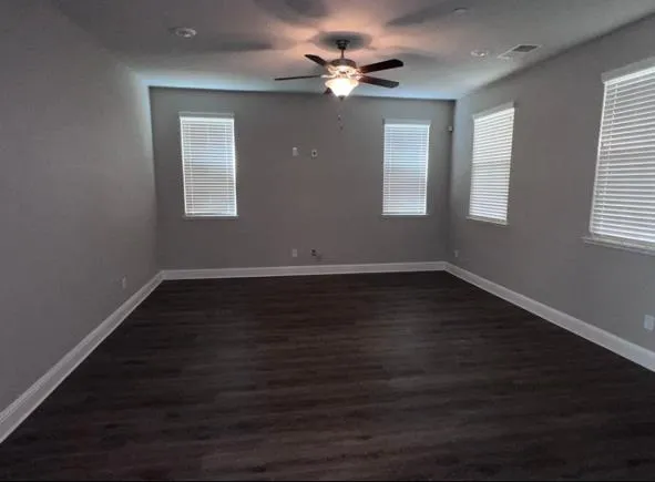 a view of wooden floor and a chandelier fan in a room