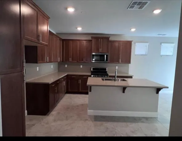 a kitchen with stainless steel appliances granite countertop a sink a stove and a refrigerator