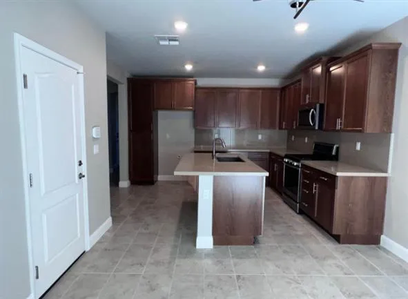 a kitchen with kitchen island granite countertop wooden cabinets and stainless steel appliances