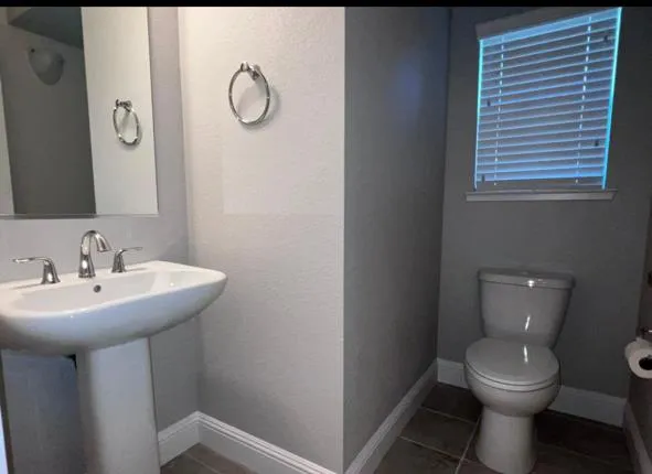 a bathroom with a toilet sink and mirror
