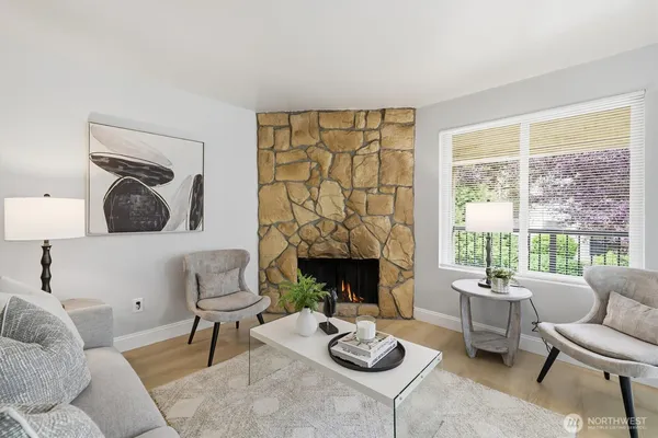 a living room with furniture a fireplace and a large window