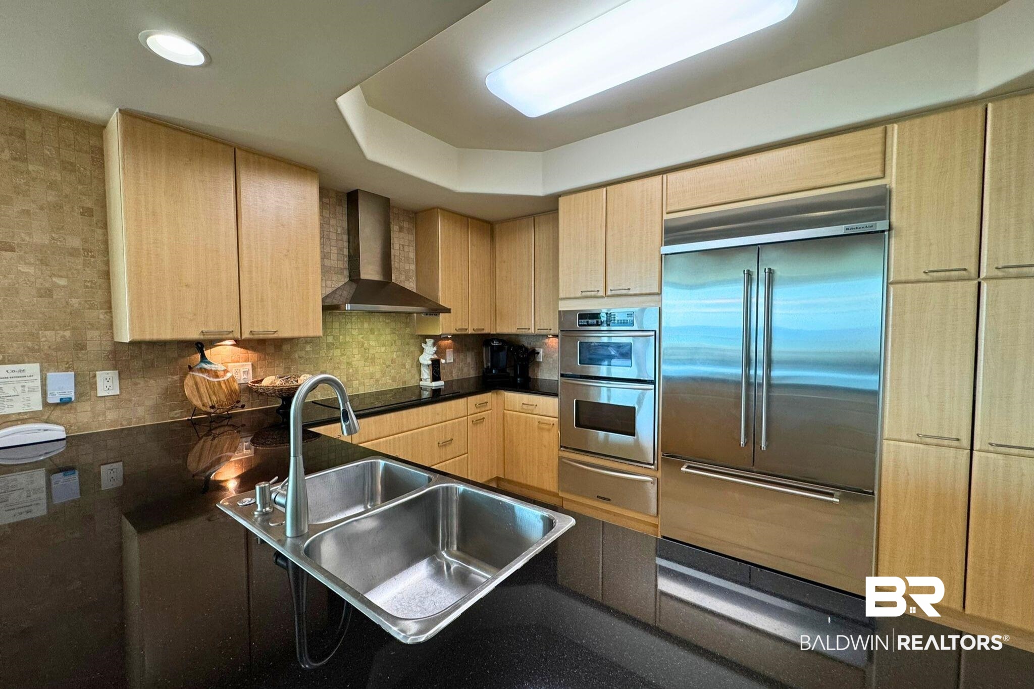 28107 Perdido Beach Boulevard, Unit D714 Orange Beach, AL 36561 - Photo 20 of 88 Kitchen with a warming drawer, stainless steel appliances, light brown cabinets, a sink, and wall chimney range hood