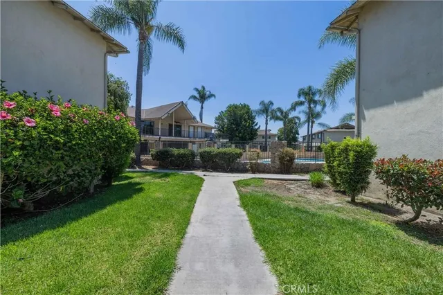 a view of a back yard with flower plants and wooden fence