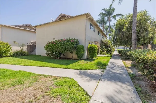 a front view of a house with a yard and potted plants