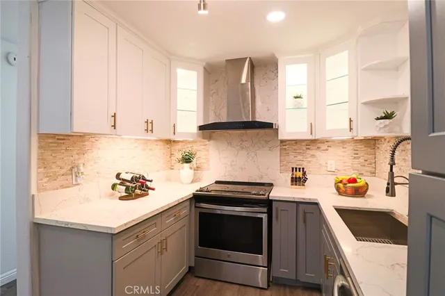 a kitchen with stainless steel appliances a sink a stove and cabinets