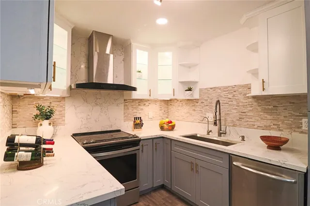 a kitchen with stainless steel appliances granite countertop a sink a stove and cabinets