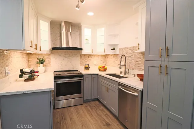 a kitchen with granite countertop white cabinets and stainless steel appliances