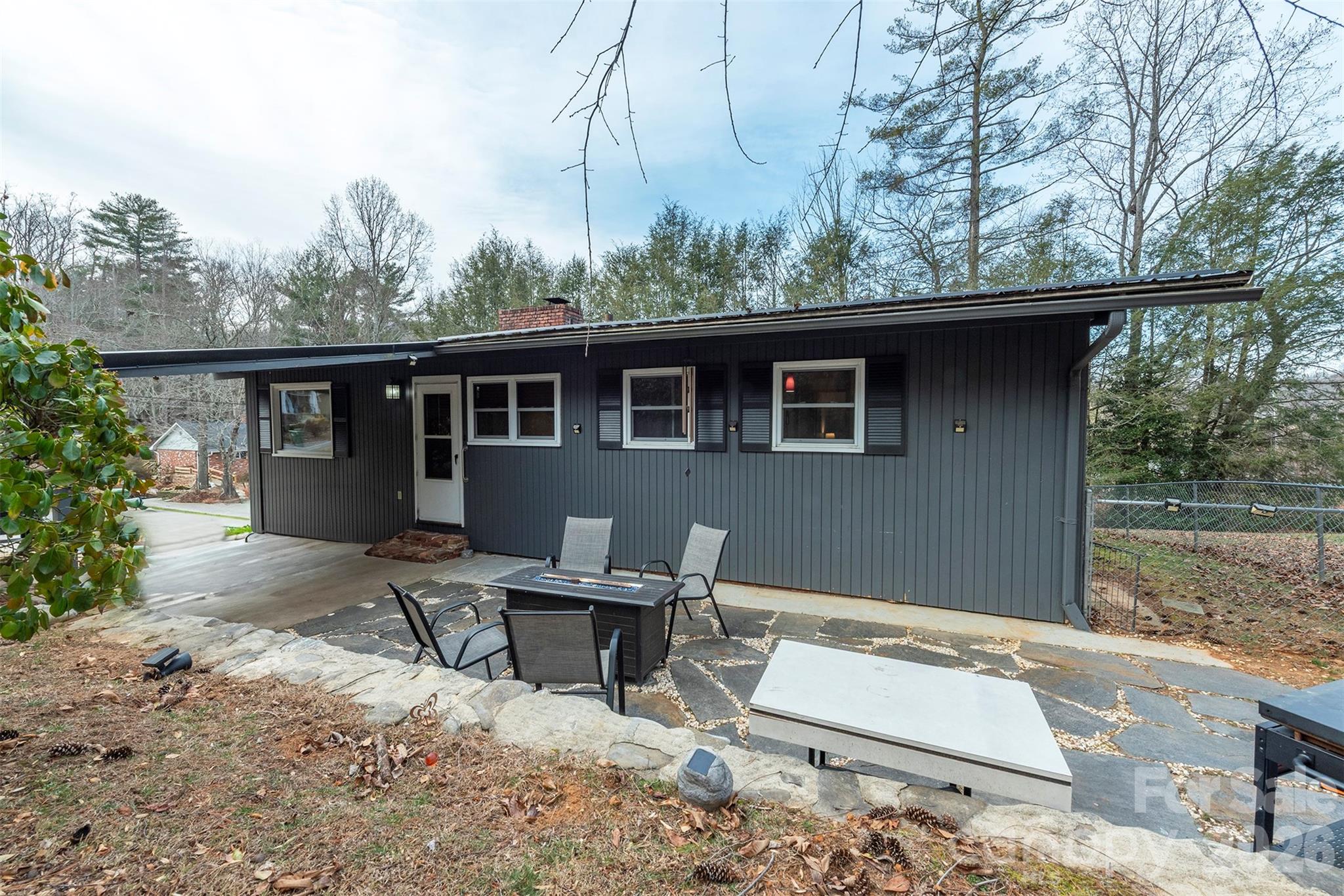 4 Stockwood Road Asheville, NC 28803 - Photo 41 of 41 a backyard of a house with large trees and wooden fence