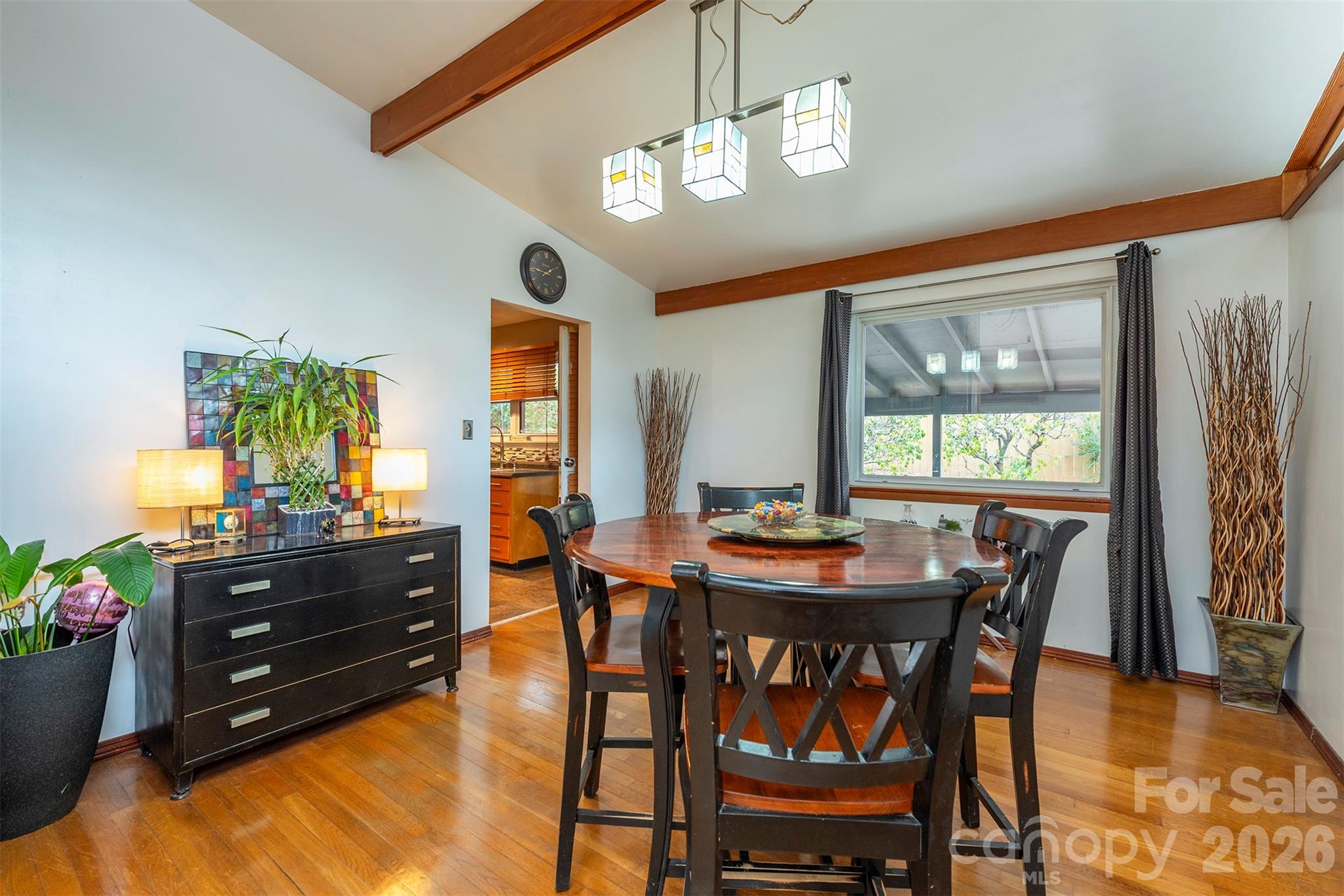 4 Stockwood Road Asheville, NC 28803 - Photo 10 of 41 a dining room with wooden floor a chandelier a wooden table and chairs