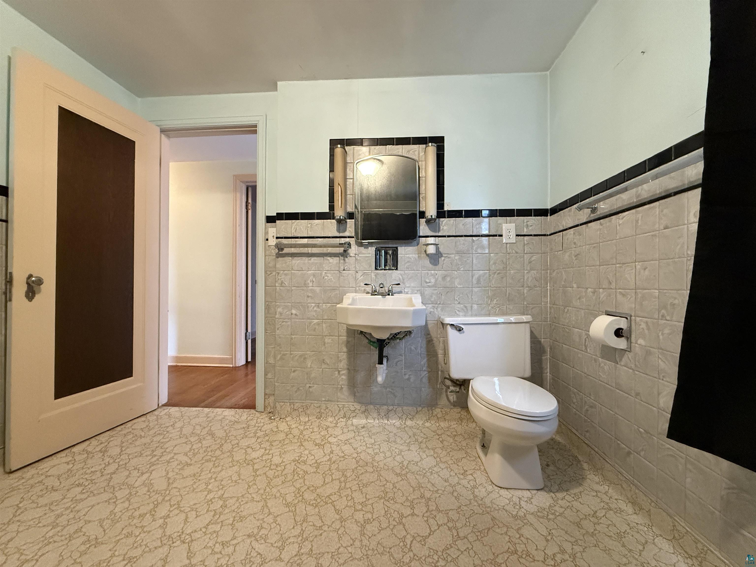 3001 3rd Avenue West Hibbing, MN 55746 - Photo 22 of 38 Half bathroom with tile walls and wainscoting