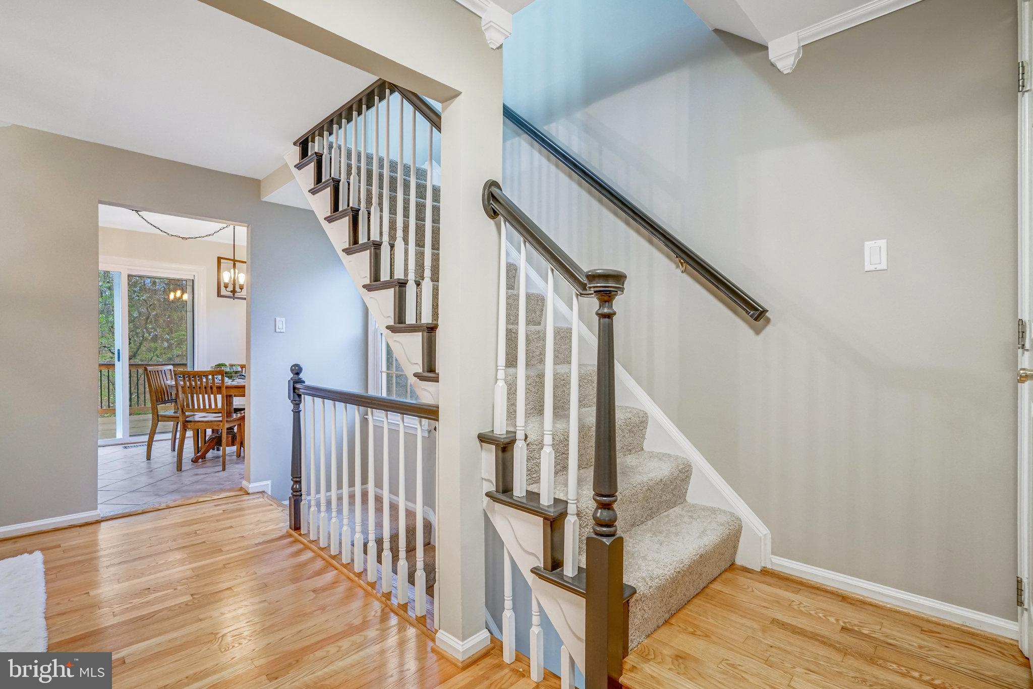 7924 Forest Path Way Springfield, VA 22153 - Photo 18 of 42 a view of staircase with lots of frames on wall and wooden floor