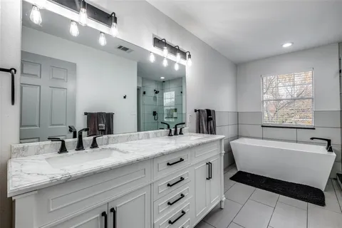 a bathroom with a granite countertop sink mirror and bathtub