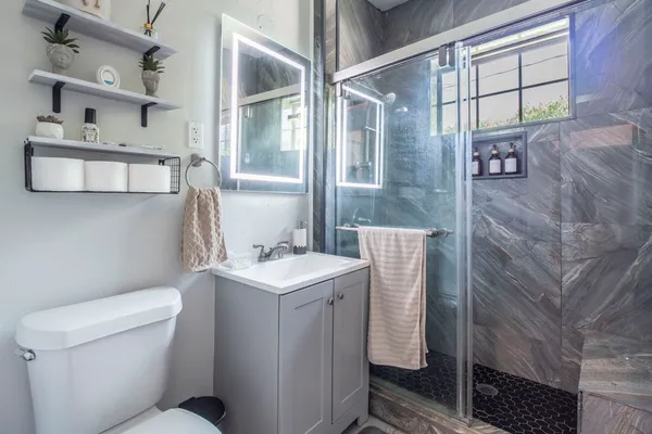 a bathroom with a sink a toilet and shower