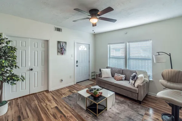 a living room with furniture and wooden floor